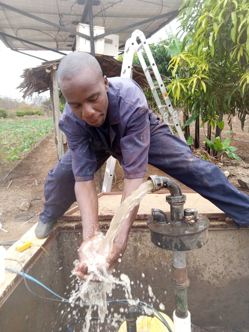 Worker testing solar-powered borehole pump